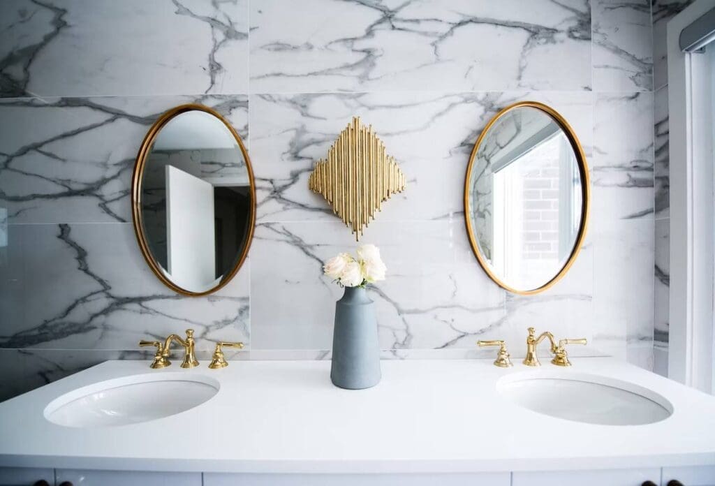 Elegant bathroom with gold fixtures and mirrors.