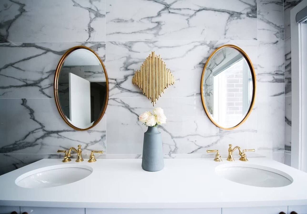 Elegant bathroom with gold fixtures and mirrors.