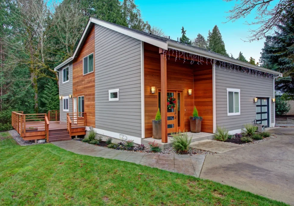 Modern house with wooden deck and driveway.
